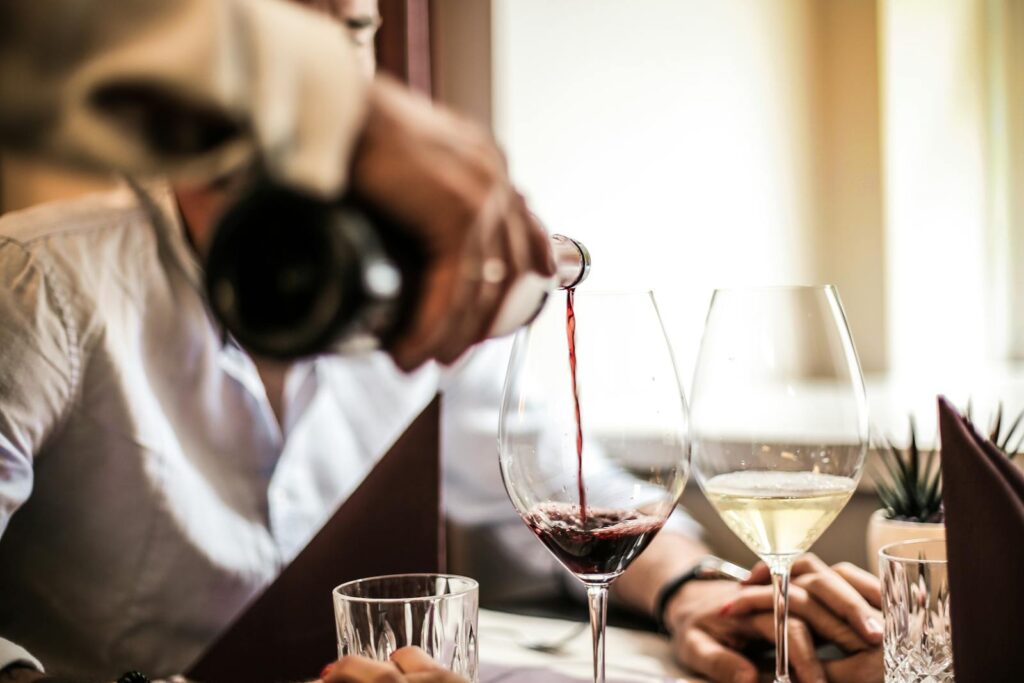 Close-up of wine being poured during an elegant romantic dinner setting with two people.