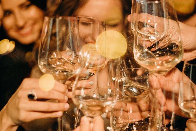 Group of people toasting with champagne glasses during a festive New Year's Eve party.