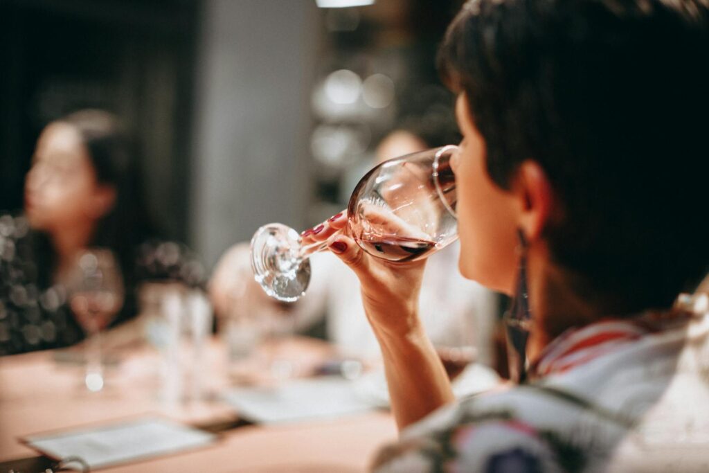 A group of adults enjoying wine together indoors in a warm social setting.