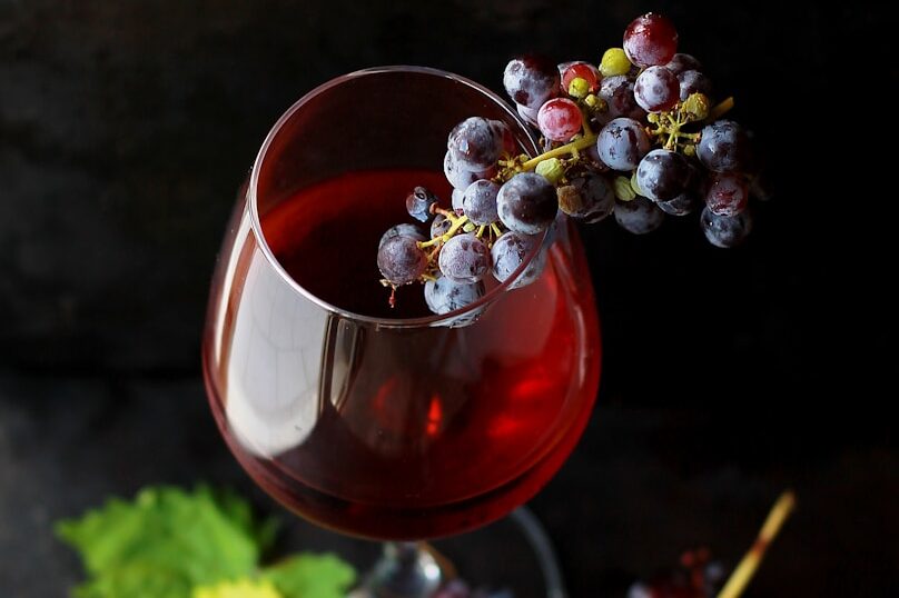 red grapes on clear glass wine