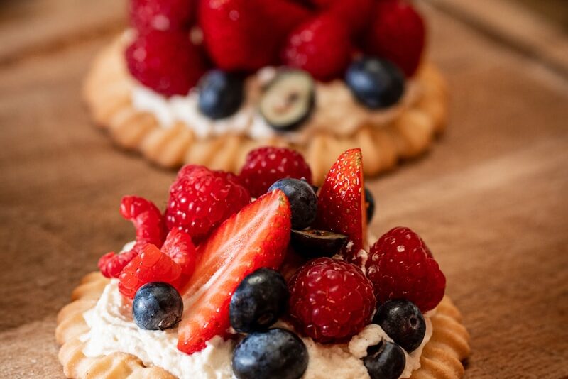 strawberry and blueberry pie on brown wooden table