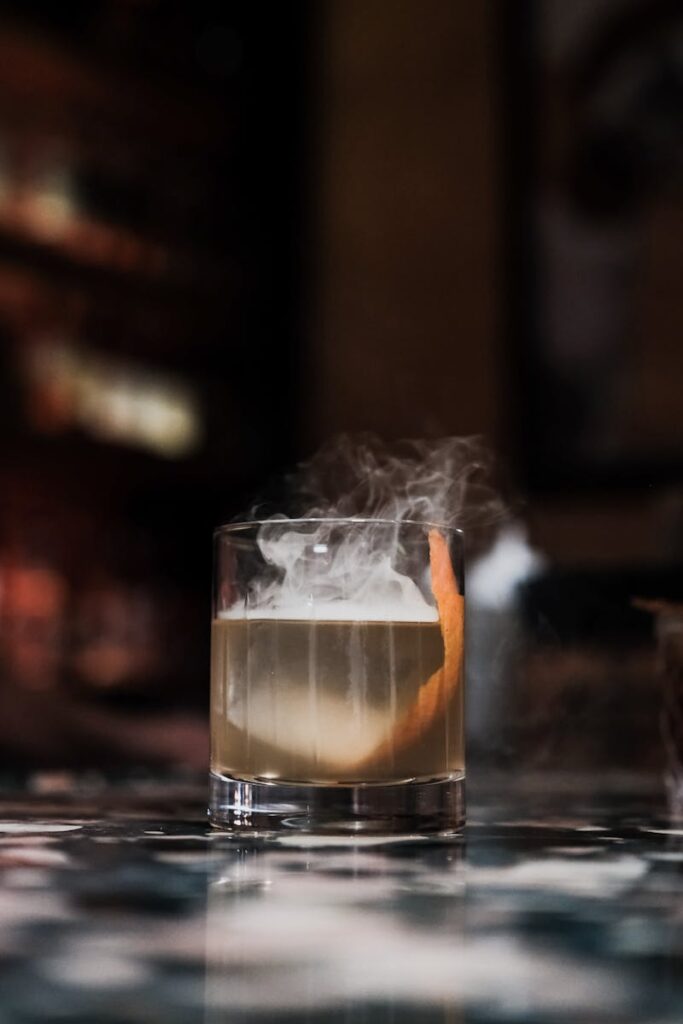 A smoky cocktail served in a sophisticated bar, showcasing a luxurious ambiance and high-class mixology.