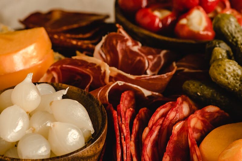 Delicious charcuterie board featuring salami, pickles, onions, and peppers in a cozy, rustic setting.