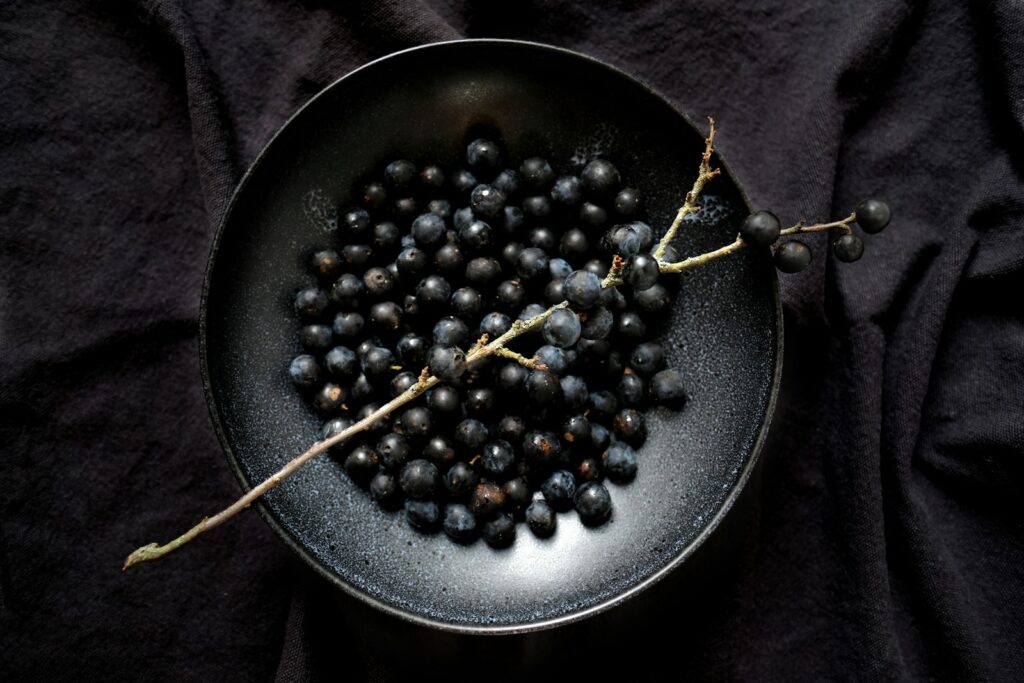 a black plate with a bunch of grapes on it