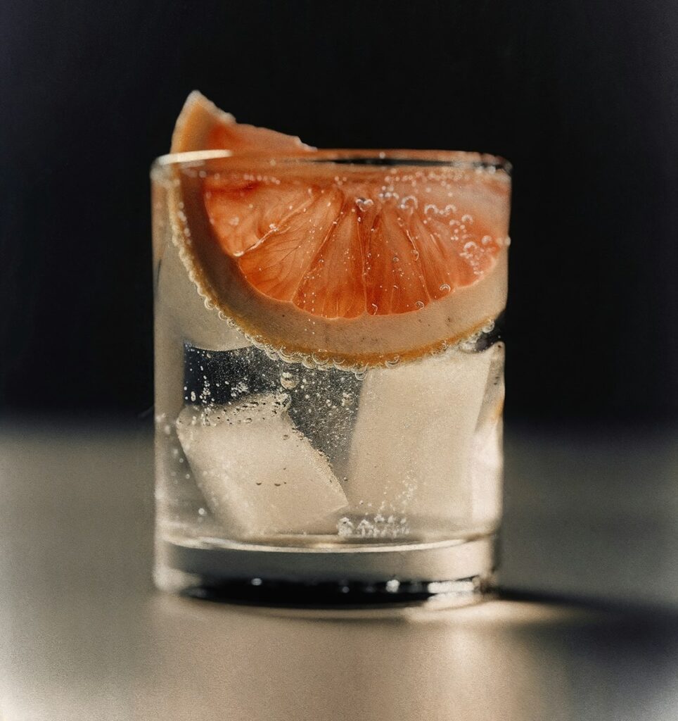 A glass of water with a slice of orange in it