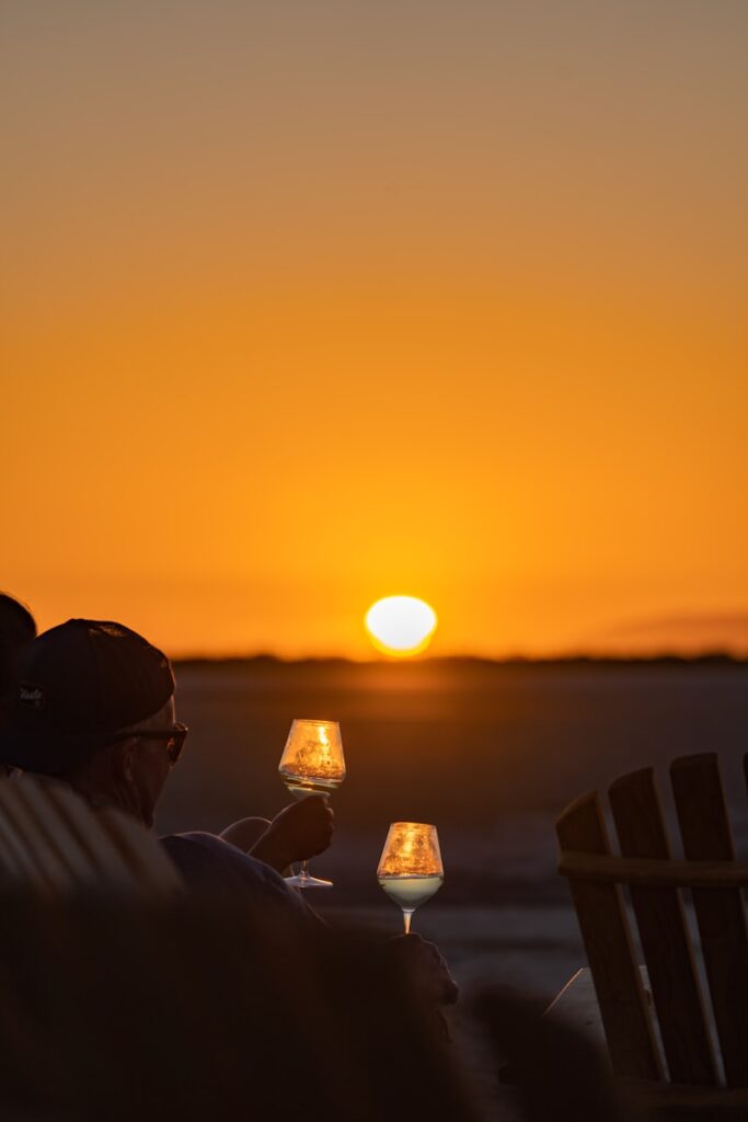 a couple of people sitting on top of a beach